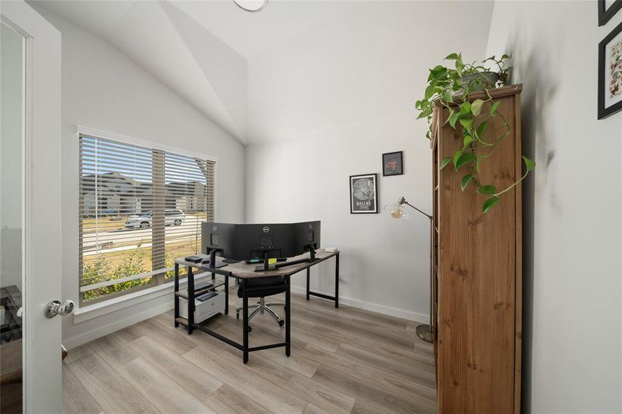 Office space featuring lofted ceiling and light wood-type flooring