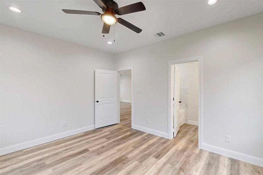 Unfurnished bedroom with ceiling fan and light hardwood / wood-style flooring