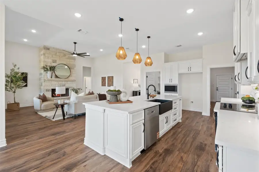 Kitchen featuring white cabinetry, dark wood-type flooring, light stone counters, a ceiling fan, and recessed lighting Kitchen featuring white cabinetry, dark wood-type flooring, light stone counters, a ceiling fan, and recessed lighting