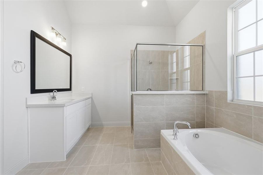 Full bathroom with a bath, healthy amount of natural light, vanity, and a shower stall
