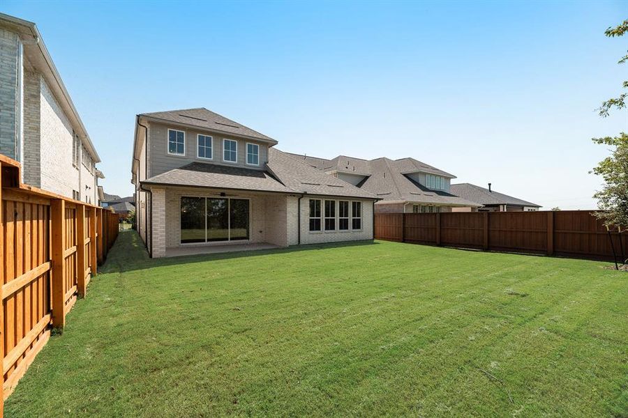 Rear view of house featuring a fenced backyard, brick siding, a patio area, and a shingled roof Rear view of house featuring a fenced backyard, brick siding, a patio area, and a shingled roof