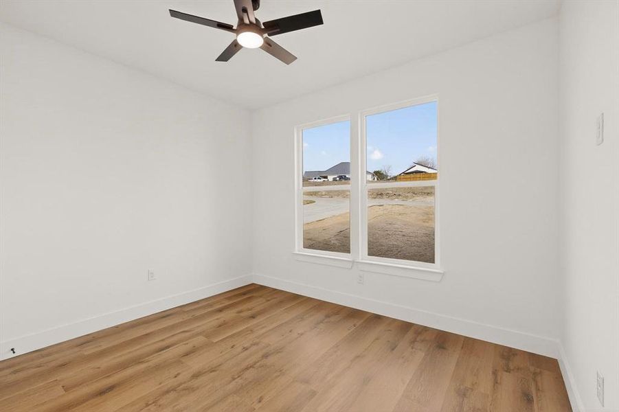 Empty room with light wood-type flooring and ceiling fan Empty room with light wood-type flooring and ceiling fan