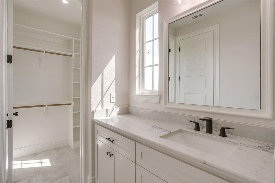 BEDROOM 4 Vanity with quartz countertops, and Large  walk in closet with window.