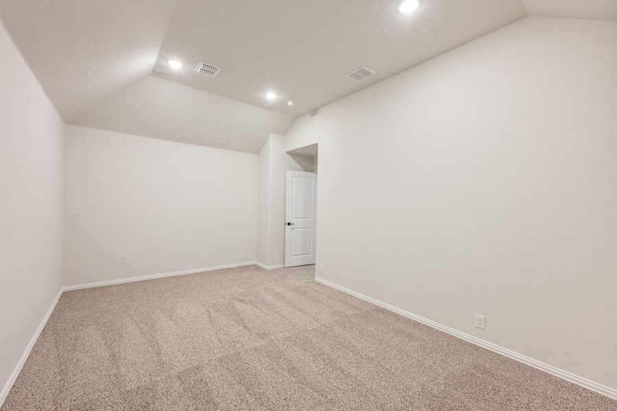 Empty bedroom with vaulted ceiling, recessed lighting, and beige carpet Empty bedroom with vaulted ceiling, recessed lighting, and beige carpet
