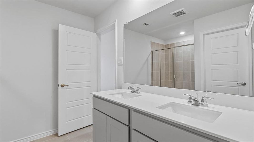 Full bathroom with double vanity, a stall shower, light tile patterned flooring, and recessed lighting