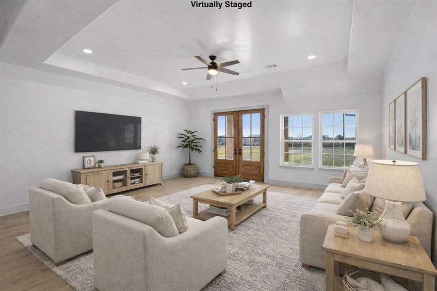 Living room featuring ceiling fan, light wood-style flooring, french doors, a raised ceiling, and recessed lighting