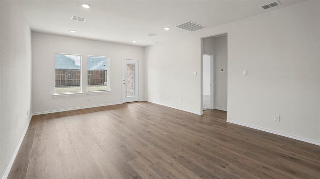 Open concept room featuring wood-finish flooring, recessed lighting, and white baseboards