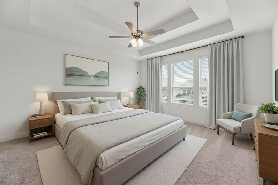 Bedroom with a raised ceiling, light colored carpet, and ceiling fan Bedroom with a raised ceiling, light colored carpet, and ceiling fan