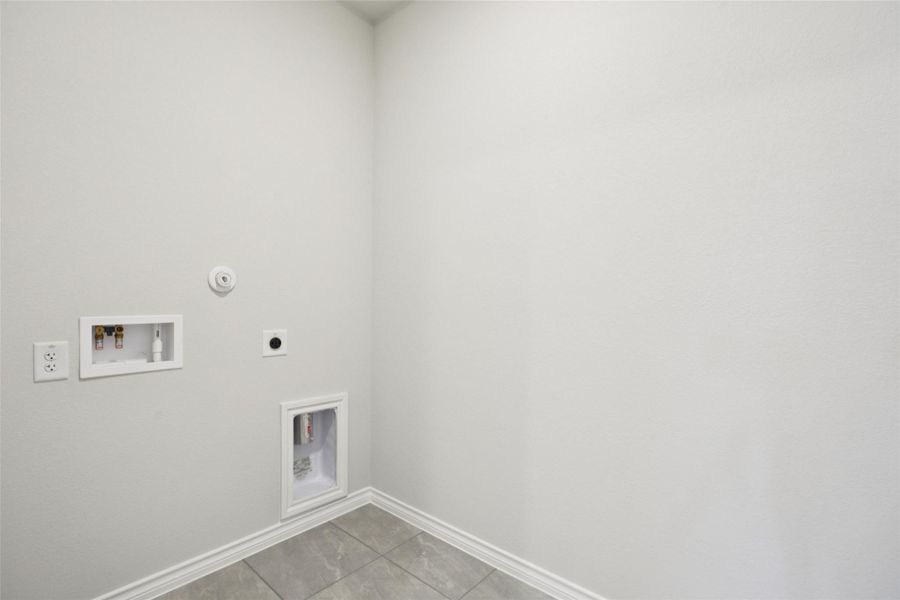 Washroom with tile patterned floors, washer hookup, hookup for an electric dryer, and gas dryer hookup Washroom with tile patterned floors, washer hookup, hookup for an electric dryer, and gas dryer hookup