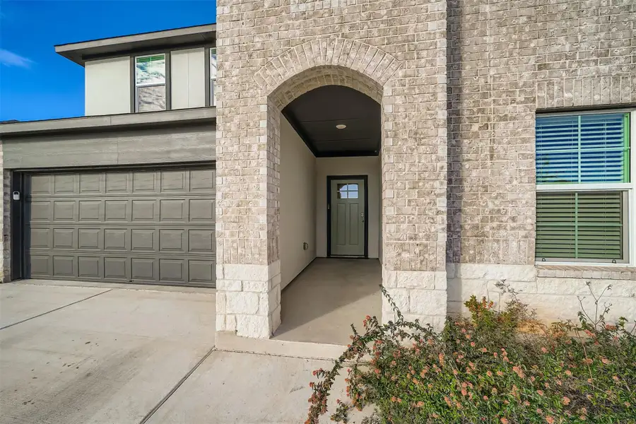 Property entrance with concrete driveway and a garage