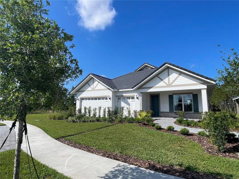 Front exterior of a new home in Tamarack at Two Rivers, Zephyrhills, FL, highlighting curb appeal (Image 2). Front exterior of a new home in Tamarack at Two Rivers, Zephyrhills, FL, highlighting curb appeal (Image 2).