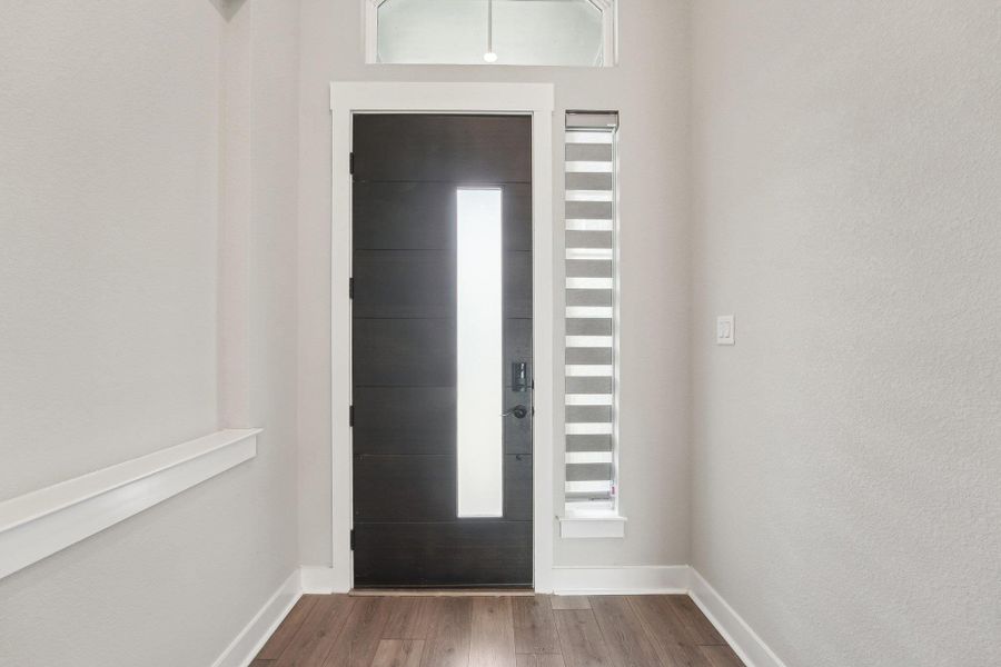 Foyer featuring baseboards and dark wood-style flooring Foyer featuring baseboards and dark wood-style flooring