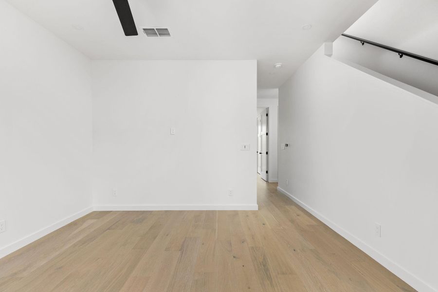 Spare room with a ceiling fan and light wood-style flooring