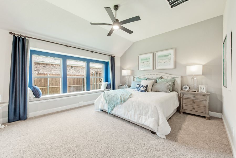 Bedroom with vaulted ceiling, ceiling fan, window seat, and carpet flooring
