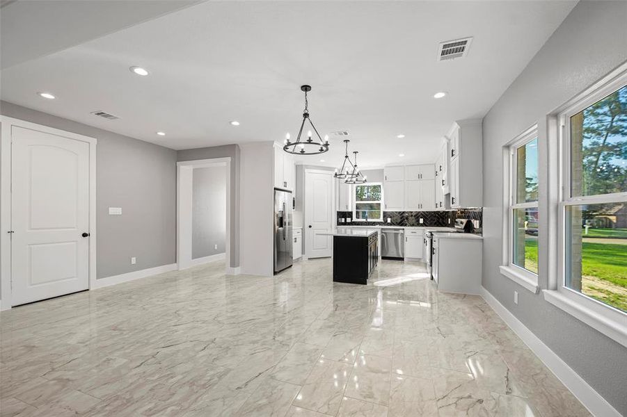 The kitchen opens into the breakfast/dining area and the family room with large windows to let in lots of sunlight. Ceramic tile flooring is included throughout this entire home.