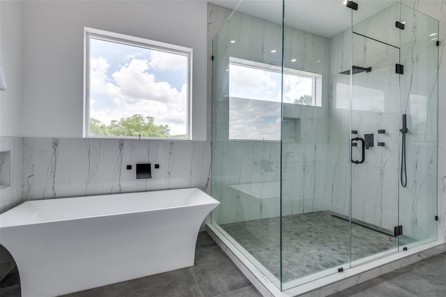 Bathroom featuring independent shower and bath, tile patterned flooring, and tile walls