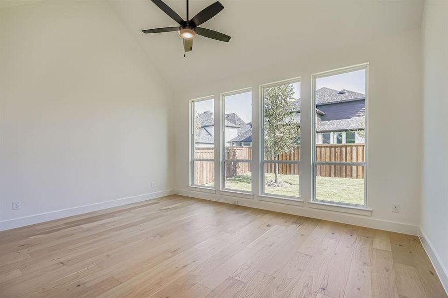 Unfurnished room with high vaulted ceiling, light wood-style flooring, and ceiling fan