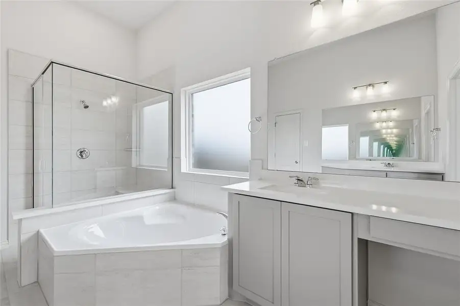 Bathroom with vanity, a stall shower, and a bath