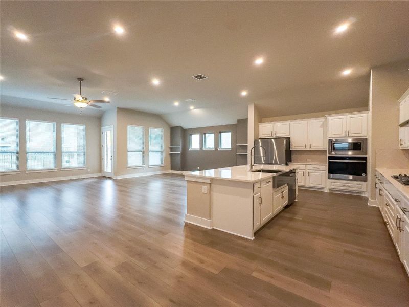 Kitchen featuring white cabinets, recessed lighting, open floor plan, stainless steel appliances, and dark wood-style flooring Kitchen featuring white cabinets, recessed lighting, open floor plan, stainless steel appliances, and dark wood-style flooring