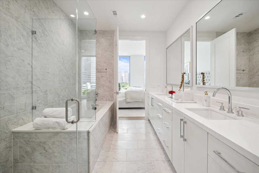 Primary bathroom with dual sinks, separate tub and walk-in shower.