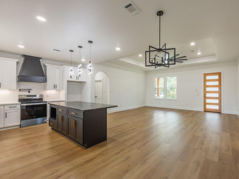 This gourmet kitchen boasts sleek black and white cabinetry, bold pendant lighting, a large center island with bar seating, and a custom range hood—combining style and function in one impressive space. This gourmet kitchen boasts sleek black and white cabinetry, bold pendant lighting, a large center island with bar seating, and a custom range hood—combining style and function in one impressive space.
