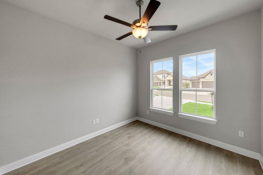 Unfurnished room featuring light wood-style floors, ceiling fan, and a residential view Unfurnished room featuring light wood-style floors, ceiling fan, and a residential view