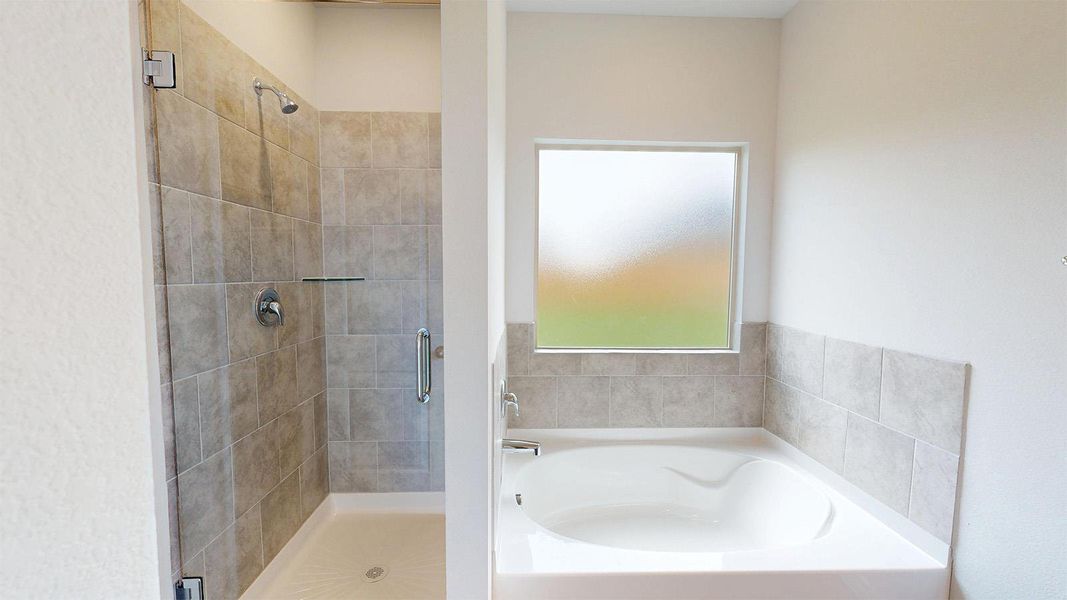 Bathroom featuring a tiled standing shower with a glass enclosure and a separate built-in bathtub with a tiled surround