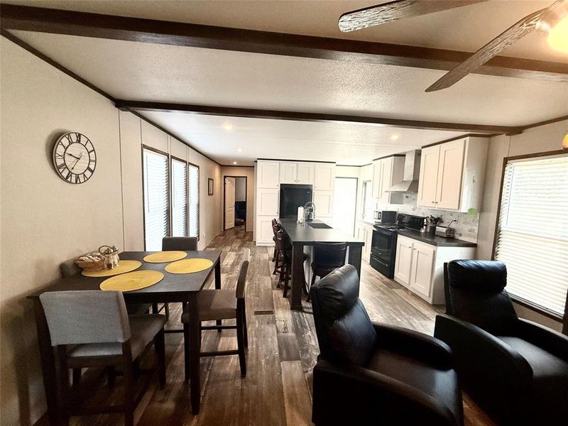 Dining room with beam ceiling and dark wood-style flooring