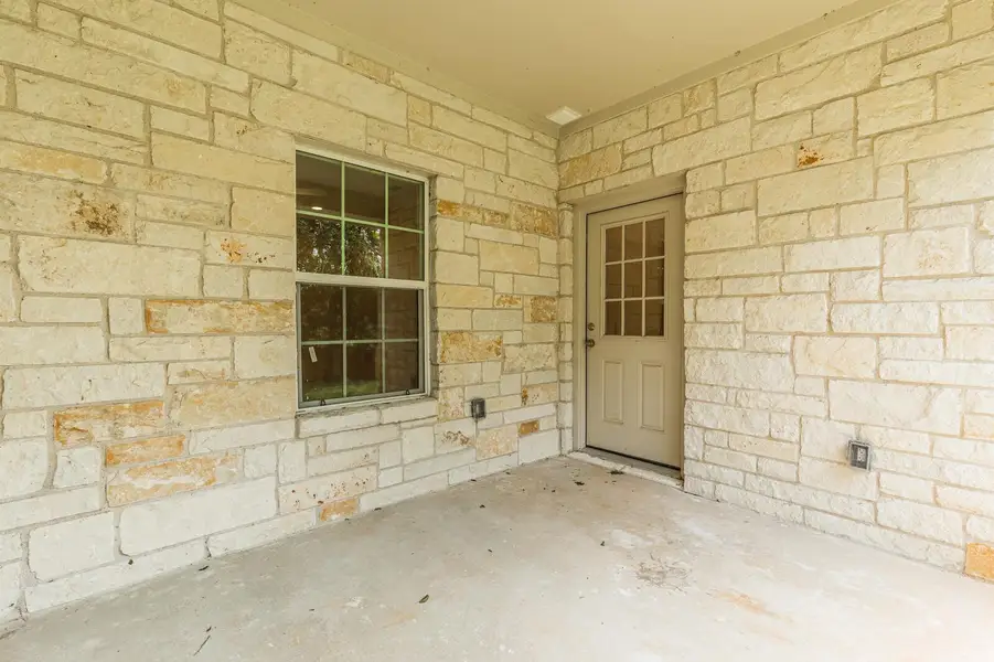 Entrance to property featuring stone siding