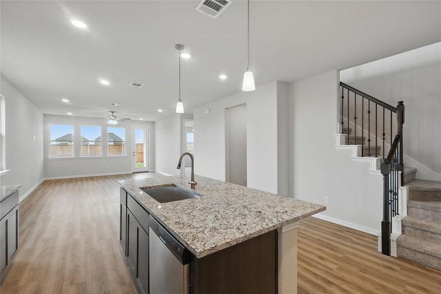 Kitchen featuring stainless steel dishwasher, light wood-style floors, a ceiling fan, decorative light fixtures, and recessed lighting Kitchen featuring stainless steel dishwasher, light wood-style floors, a ceiling fan, decorative light fixtures, and recessed lighting