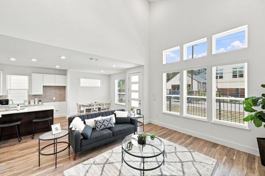 Light-filled living space featuring a dramatic wall of windows and high ceilings that create an open, airy atmosphere. Light-filled living space featuring a dramatic wall of windows and high ceilings that create an open, airy atmosphere.