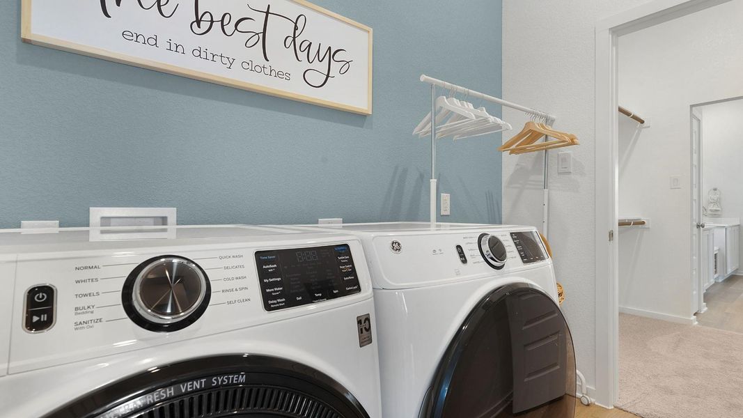 A well-appointed laundry area features modern appliances and a convenient hanging rack, promoting efficiency in daily routines. A well-appointed laundry area features modern appliances and a convenient hanging rack, promoting efficiency in daily routines.