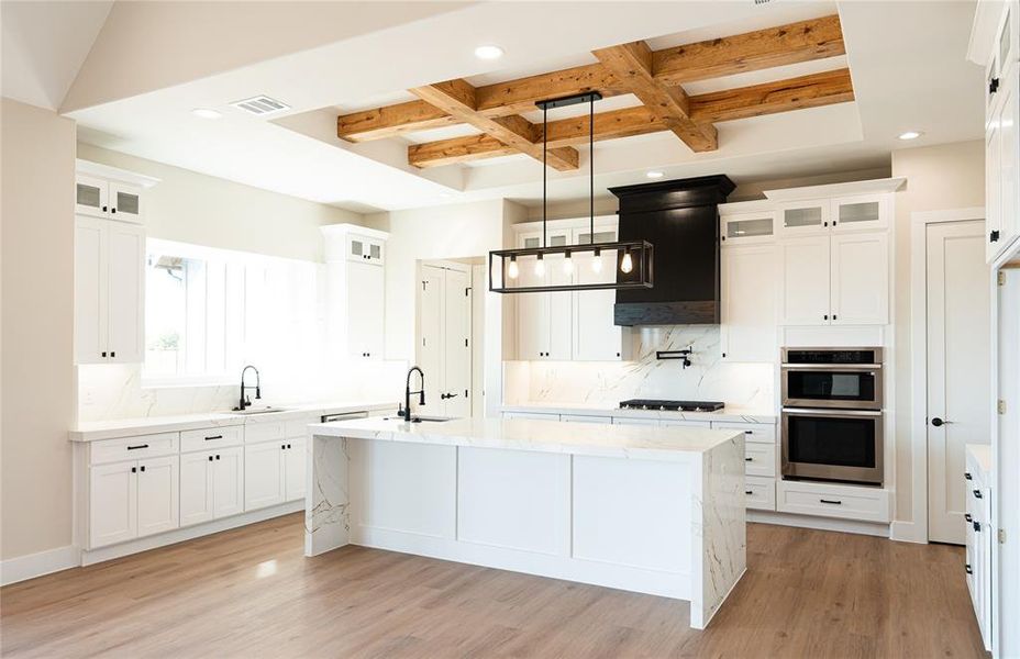 Kitchen featuring backsplash, glass insert cabinets, light stone countertops, coffered ceiling, and white cabinets