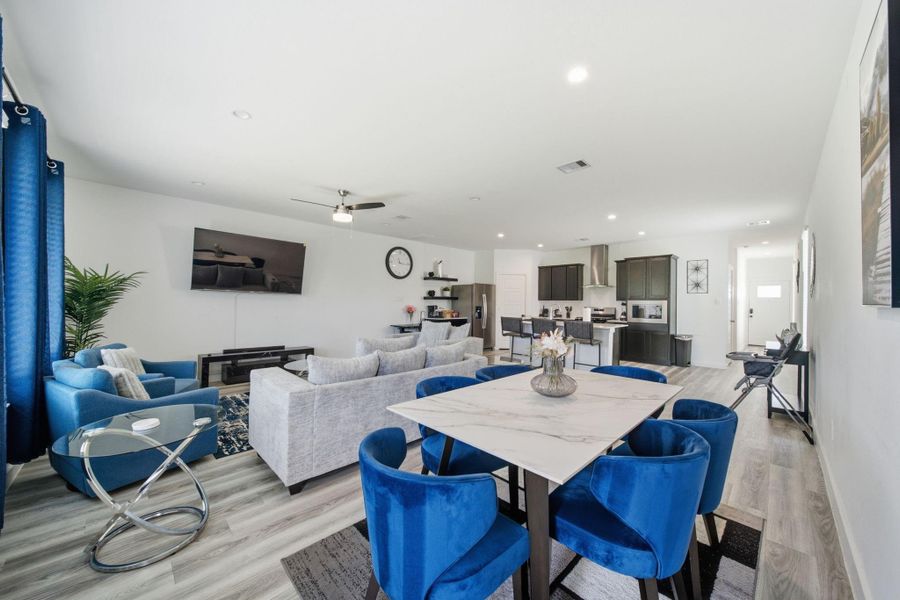Open-concept dining area seamlessly flows into the living room and kitchen, complemented by abundant natural light for a bright and inviting atmosphere.