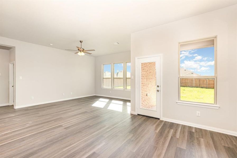 Spare room featuring a ceiling fan, baseboards, and wood finished floors