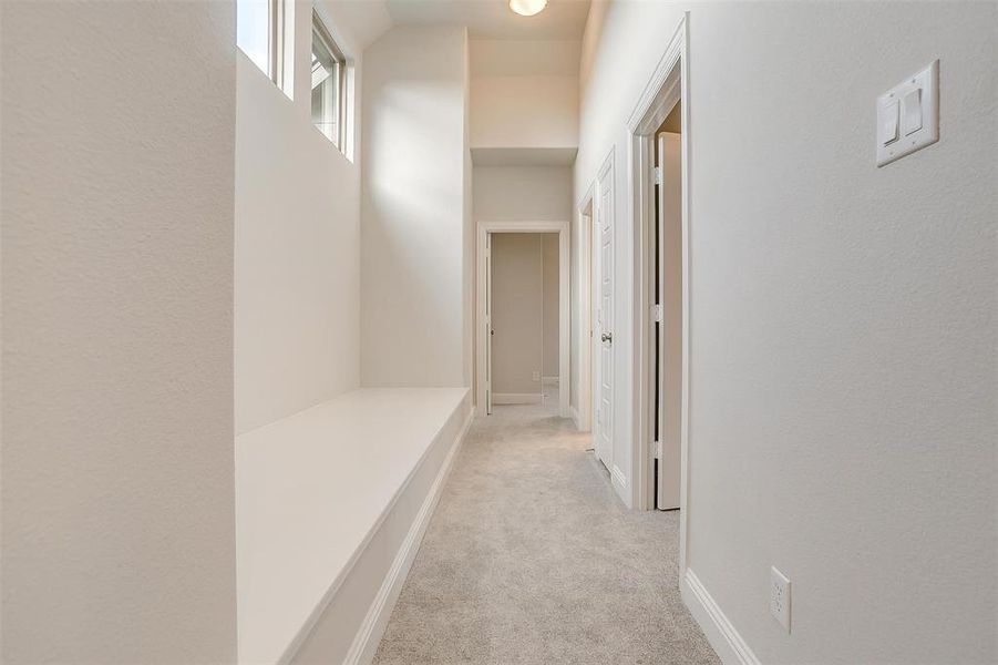 Hallway featuring light colored carpet