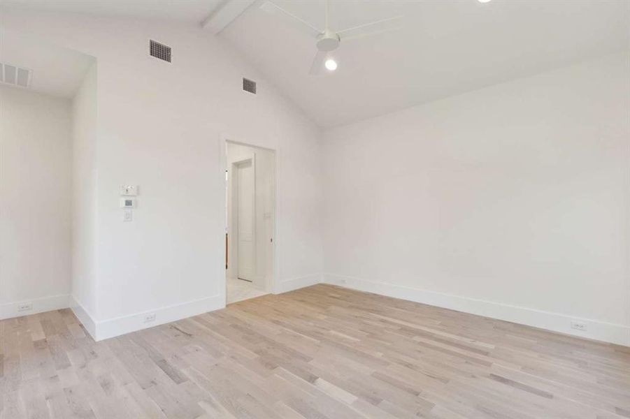 Spare room featuring light hardwood / wood-style floors, beamed ceiling, and ceiling fan