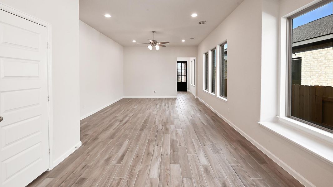 Empty room with recessed lighting, plenty of natural light, light wood-style floors, and a ceiling fan