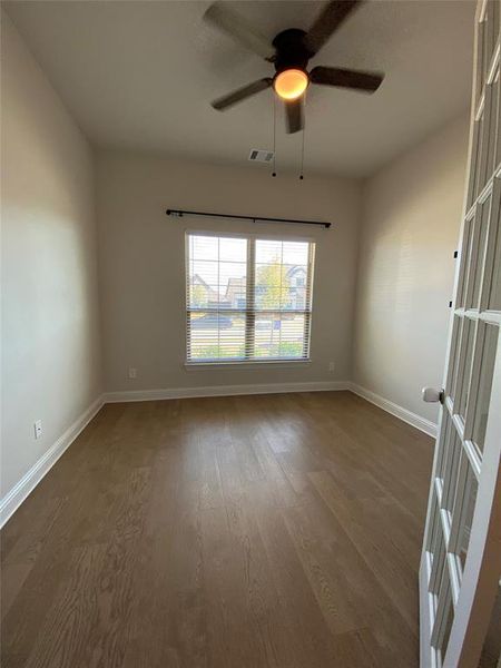 Spare room featuring wood finished floors and a ceiling fan Spare room featuring wood finished floors and a ceiling fan
