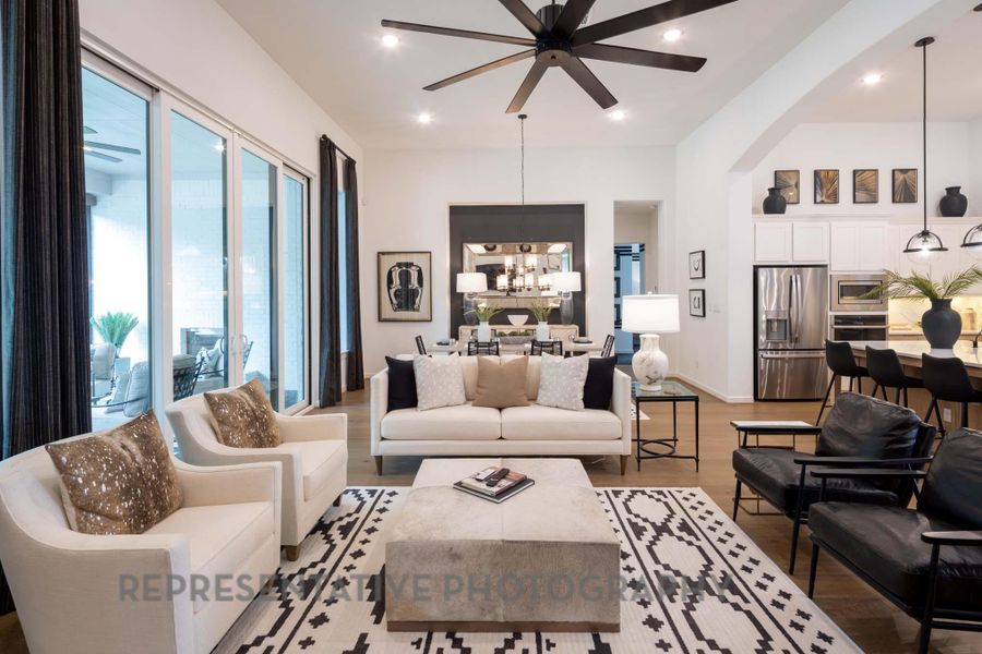 Living room featuring a chandelier, light wood-style floors, a ceiling fan, arched walkways, and recessed lighting Living room featuring a chandelier, light wood-style floors, a ceiling fan, arched walkways, and recessed lighting