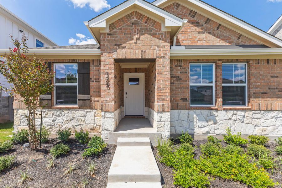 Front exterior of a new home in Flora, Hutto, TX, highlighting curb appeal (Image 19). Front exterior of a new home in Flora, Hutto, TX, highlighting curb appeal (Image 19).