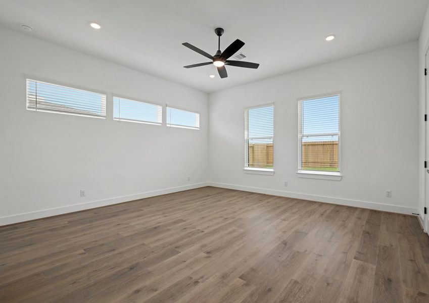 Primary bedroom with large windows.
