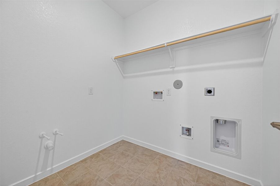 This laundry room provides plenty of space for your washer, dryer, and storage needs, making everyday chores simple and convenient.