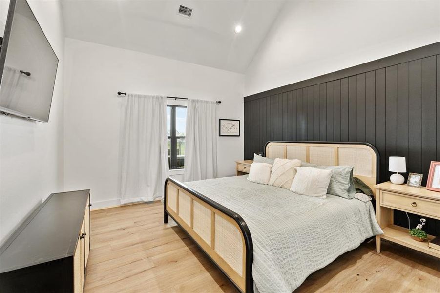 Bedroom with light wood finished floors, high vaulted ceiling, and recessed lighting