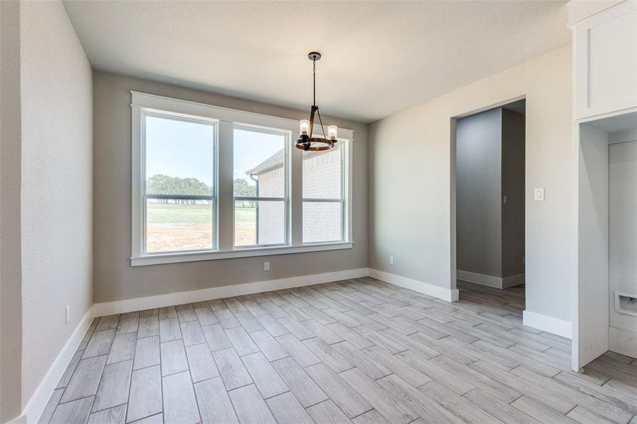 Spare room with an inviting chandelier and light hardwood / wood-style flooring