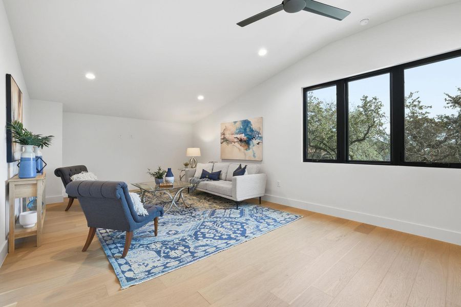 Living area with light wood-style floors, vaulted ceiling, a ceiling fan, and recessed lighting