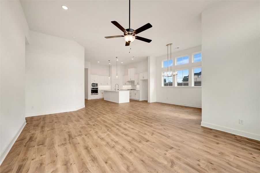 Open-concept living area featuring wood-finish flooring, a contemporary ceiling fan, and recessed lighting