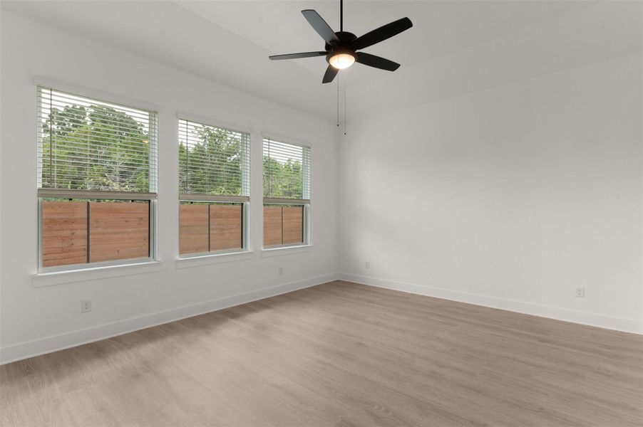 Spare room with wood finished floors and a ceiling fan Spare room with wood finished floors and a ceiling fan
