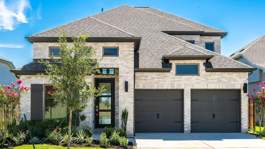 French country inspired facade featuring roof with shingles, driveway, a garage, and stone siding