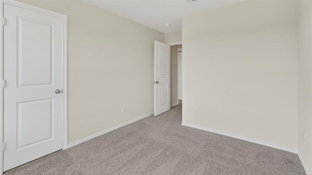Neutral wall paint throughout a room featuring gray carpet flooring and white trim